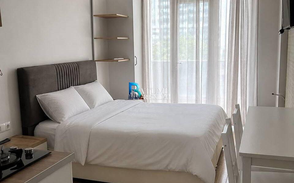 Кровать, стол и окно в квартире-студии 30 м² в LemonGarden Residence & Spa, район Аэропорт, Батуми