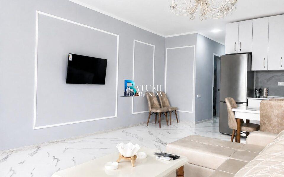 Гостиная с телевизором и кухней в 3-комнатной квартире 80 м² в ЖК Modern Residence, район Багратиони, Батуми