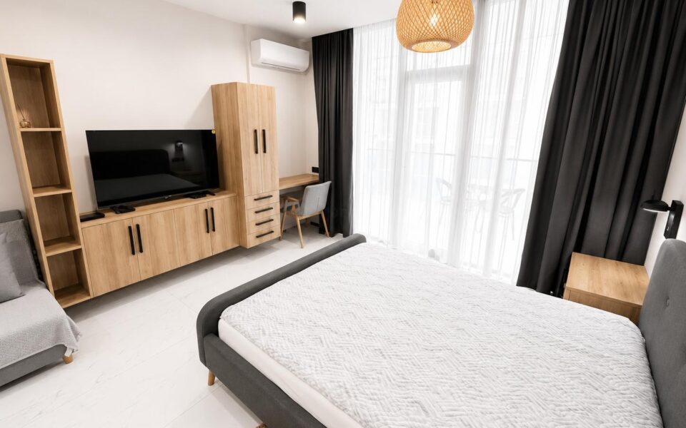 Мебельная горка, телевизор, кровать и окно в новой квартире Ande Tower 2 в Батуми